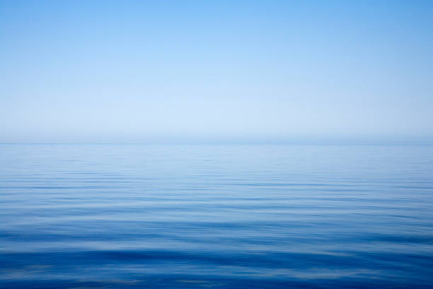 Background of sky and sea, sea is very calm with gentle ripples, sky perfectly clear.