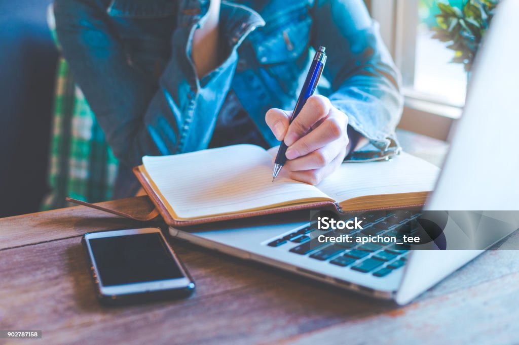 Woman hands with pen writing on notebook in the office. Writing - Activity Stock Photo