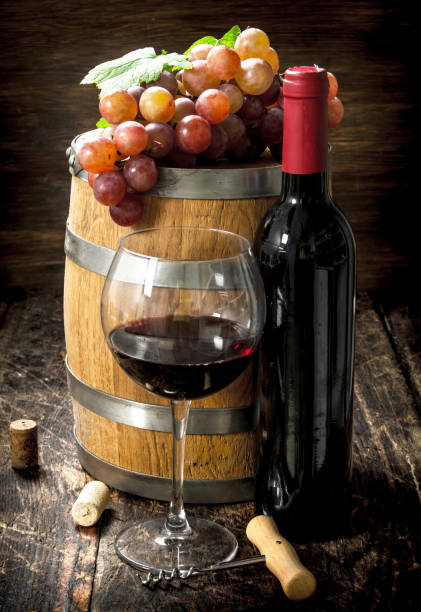 istock barrel of red wine with grapes and a corkscrew. 902787224