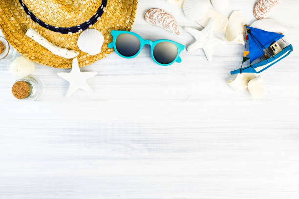 istock Summer Beach accessories (White sunglasses,starfish,straw hat,glass bottle,shell) on white plaster wood table top view,Summer vacation concept,Leave space for adding text 902789706