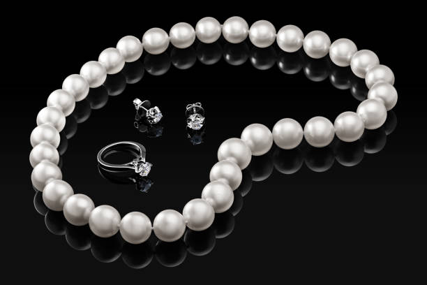豪華なセット白い真珠のネックレスとジュエリー ダイヤモンドのリングとピアス黒背景に光沢のある反射、あなたのデザインやコピーのスペースのための空のテンプレートのテキスト - pearl necklace earring jewelry ストックフォトと画像
