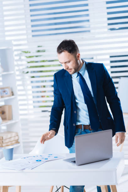 istock Busy young man looking at his table while preparing for a meeting 902789952