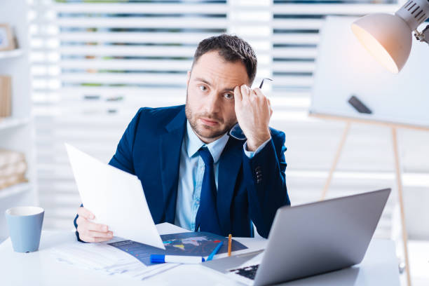 istock Young exhausted manager sitting with his head leaning on his fist 902793544