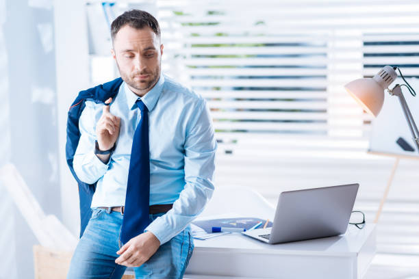 istock Peaceful young worker sitting on a table and looking bored 902793698