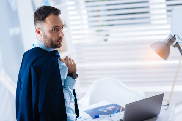 istock Handsome man standing with a jacket on his shoulder before going home 902793726