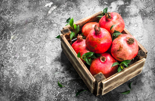 istock Ripe pomegranates in a box. 902794574
