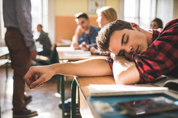 adolescente cansado cochilando na escola durante a aula. - sleeping high school desk education - fotografias e filmes do acervo