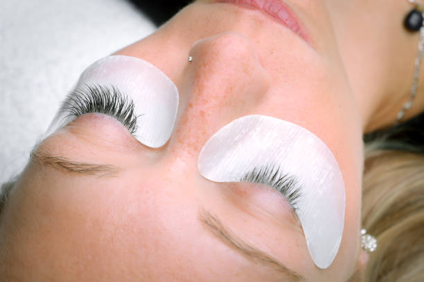 istock Eyelash extension procedure, woman eye with Long eyelashes 902805344