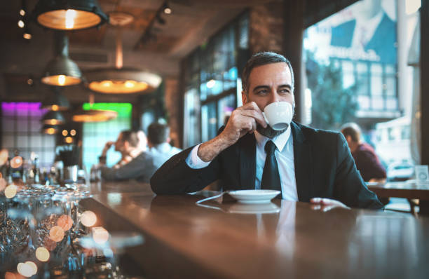 mann mit einem morgendlichen kaffee in einer bar - espresso men coffee shop drinking stock-fotos und bilder