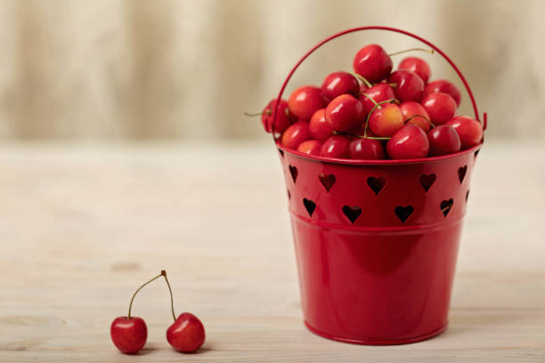 Cherries in a basket on a light wooden background. Selective focus.