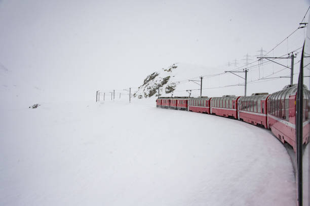 istock Red train in the snow in swiss alps 902812380