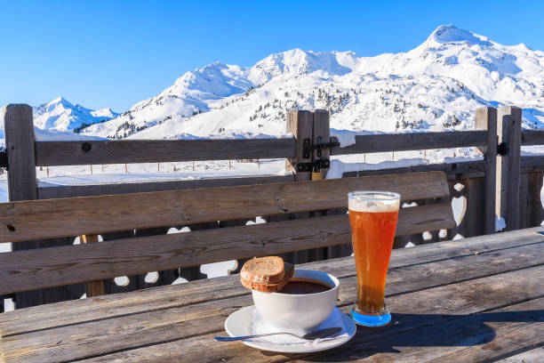 glass of cold beer and hot soup on wooden table of mountain hut in obertauern ski area, austria - ski resort winter sport apres ski ski slope imagens e fotografias de stock