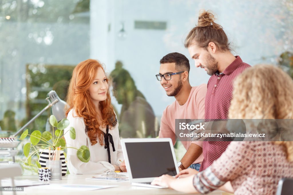 Workers at advertising agency Mixed race workers having a brainstorm at the advertising agency office Real Estate Office Stock Photo