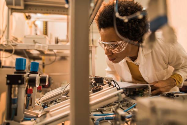 istock African American quality control inspector examining machine part on production line. 902813358