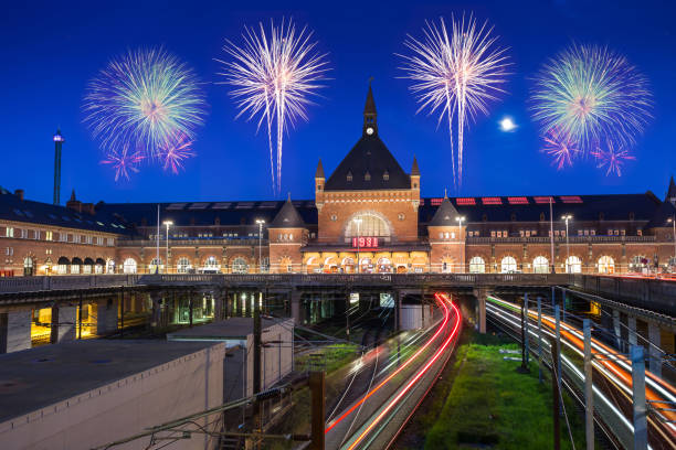 istock train run into Copenhagen central station in Denmark with clear blue sky and firework 902818530