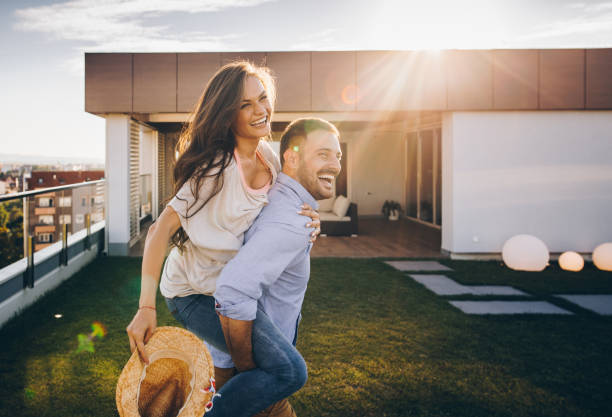 istock Joyful couple having fun while piggybacking on a penthouse terrace. 902819908