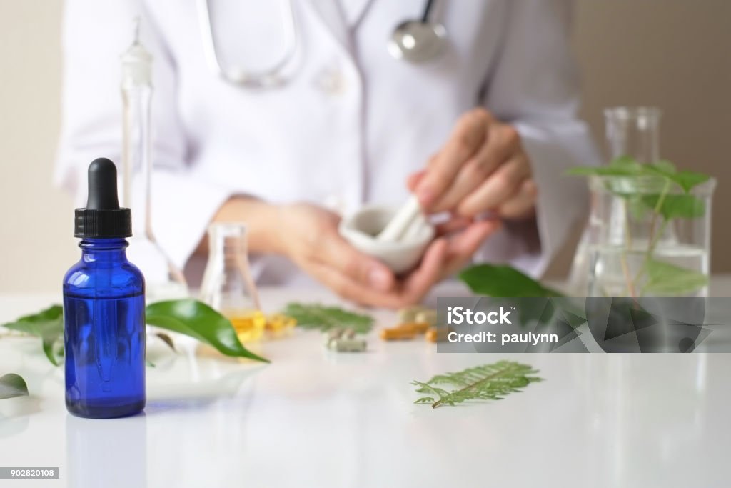 the scientist or doctor make herbal medicine from herb in the laboratory on the table .alternative treatment. show hand and stethoscope. with the bottle container. Nature Stock Photo