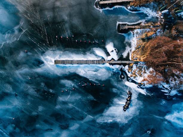 aerial view of the winter frozen lake with wooden piers captured with a drone in finland. - cold frozen sea landscape imagens e fotografias de stock
