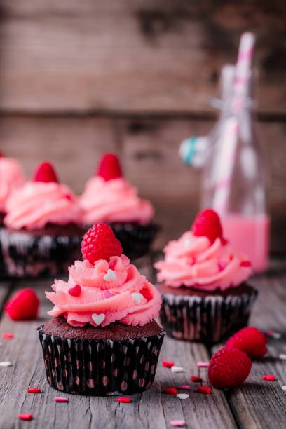 cupcakes de chocolate con crema de rosa, corazones de azúcar y frambuesas frescas para san valentín - chocolate chocolate candy cupcake pink fotografías e imágenes de stock