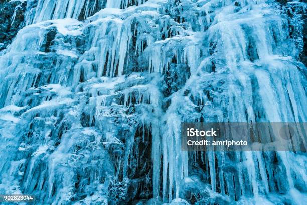 4 Seasons Many Huge Icicles Over Rock Face On Cold Winter Day Stock Photo - Download Image Now