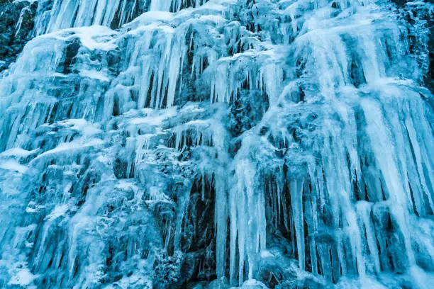 wall of many big icicles representing cold weather winter eery spooky atmosphere ice palace low perspective