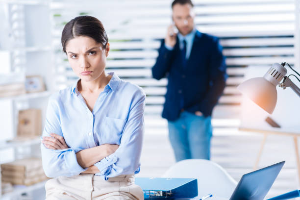 istock Upset woman pouting her lips while sitting with her arms crossed 902826662