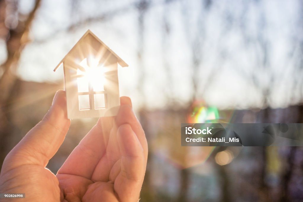 House in hand in the rays of the sun. House in hand in the rays of the sun. The concept of protection of property. House Stock Photo