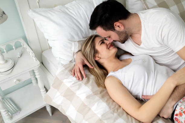 istock Young attractive couple having romantic time in bed 902830550