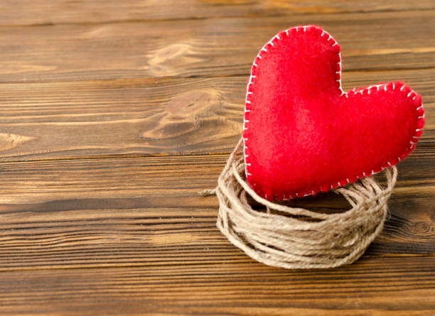 felt red heart on ribbon on wooden background felt red heart on ribbon on wooden background felt heart shape small red stock pictures, royalty-free photos & images