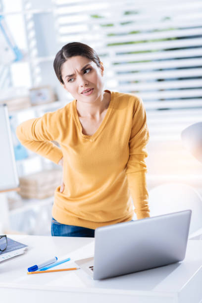 istock Tired woman frowning while standing and having a strange backache 902831278