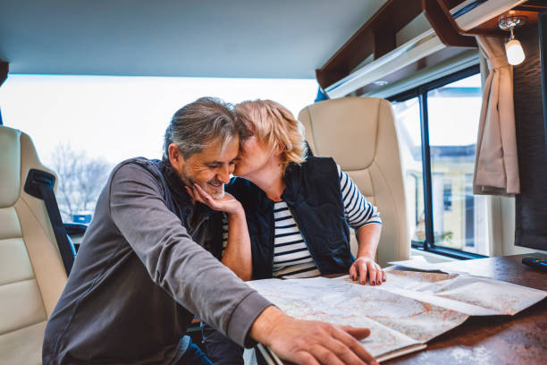 istock Woman kissing her husband while planning their next destination 902835818