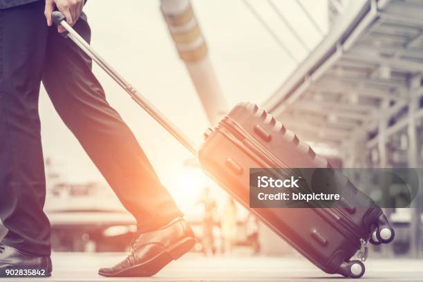 Businessman Drag Luggage And Hold Suit In City Outdoor On Building Background Concept Of Business Trip And Work Life Balance Image Processing Vintage Color Stock Photo - Download Image Now