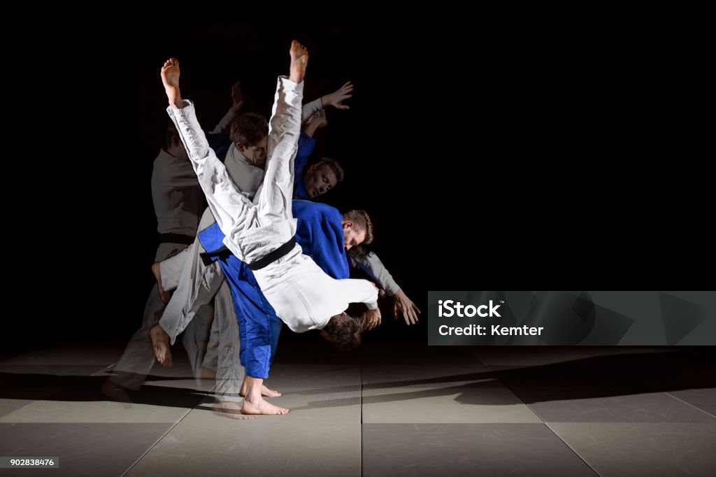 Judo training series Two black belt judo fighters throwing SODE TSURI KOMI GOSHI. Image created as multiple exposure to see the motion sequence. Judo Stock Photo