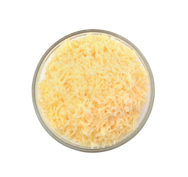 Grated cheese in a glass bowl top view isolated