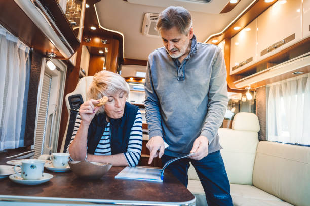 istock Cheerful mature couple eating breakfast inside of a camper 902841638