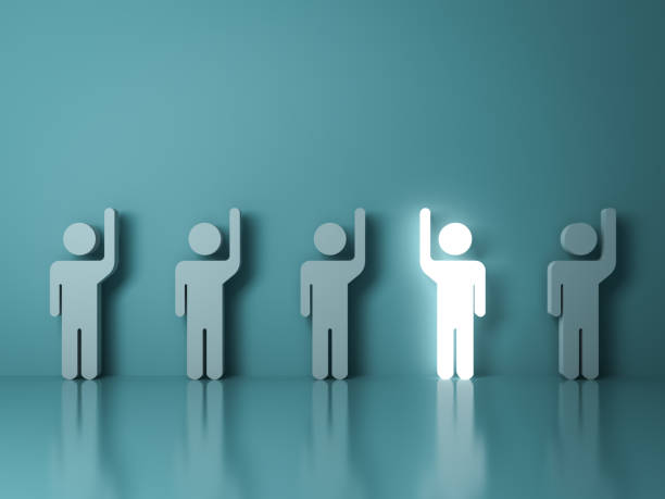 istock Stand out from the crowd and different concept , One glowing light man raising his right hand among other left hand people on light green background with reflections and shadows 902842442