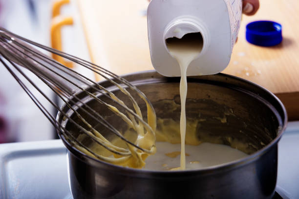 istock Milk being poured into cooking pot in the kitchen 902843120