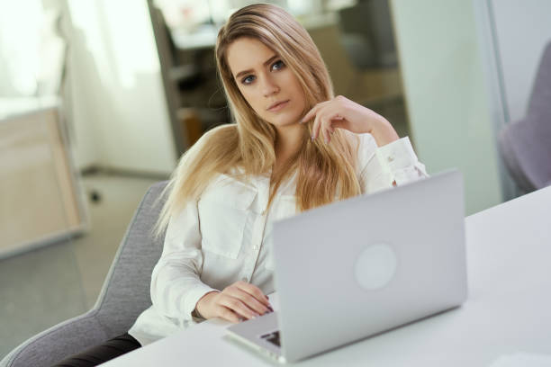 istock young businesswoman sitting at a desk with a computer 902843300