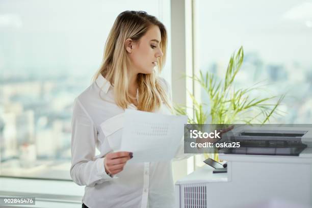 Photo libre de droit de Jeune Femme Daffaires Imprime Sur Limprimante Au Bureau banque d'images et plus d'images libres de droit de Imprimeur