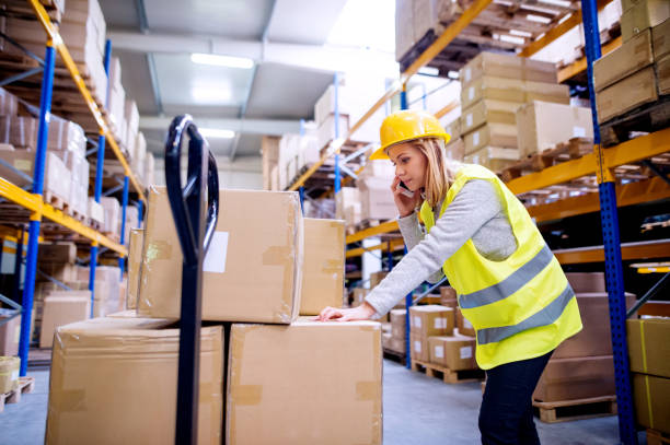 istock Woman warehouse worker with a smartphone. 902850622