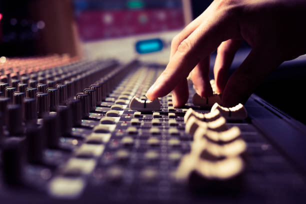 male sound engineer hands working on sound mixer for recording, broadcasting, music production background stock photo