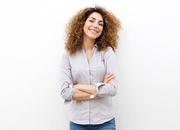sorridente giovane donna con i capelli ricci su sfondo bianco - solo una donna giovane foto e immagini stock