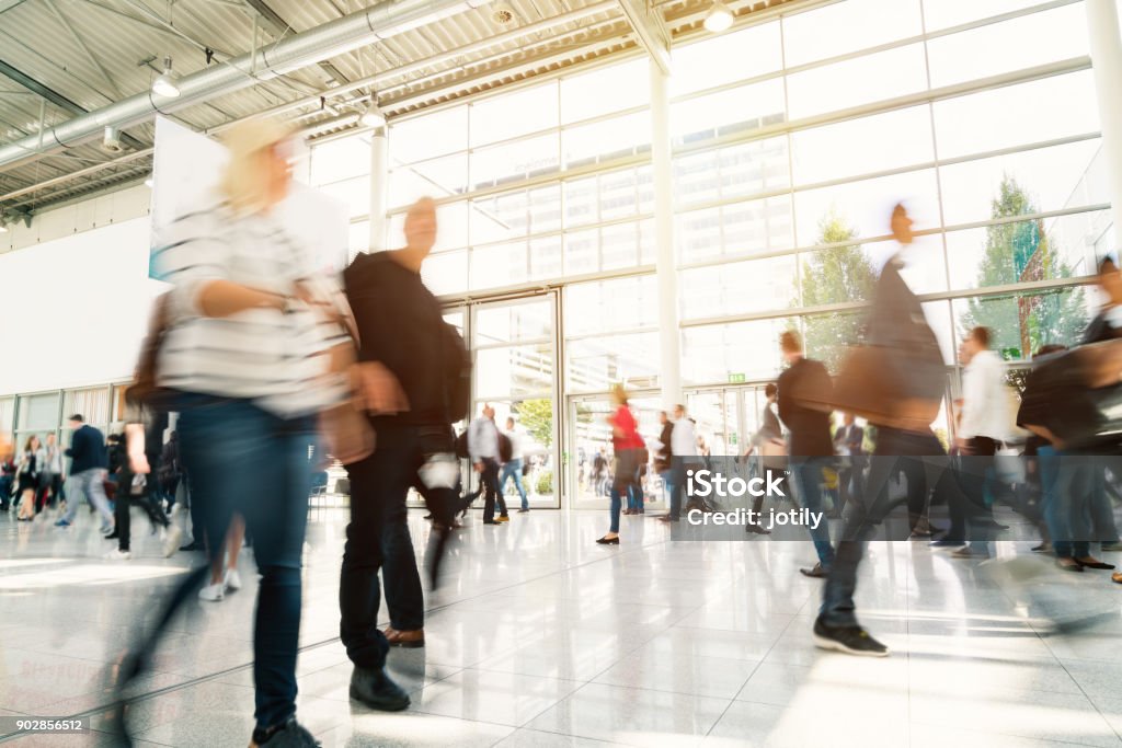 blurred people in a modern hall blurred people walking in a modern hall. Tradeshow Stock Photo