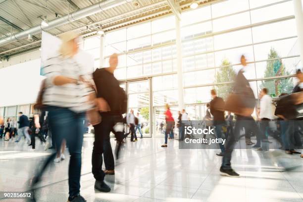 Blurred People In A Modern Hall Stock Photo - Download Image Now - Tradeshow, Exhibition, Booth