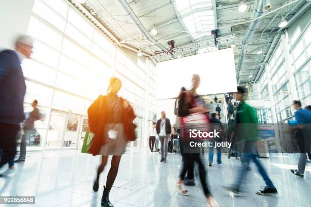 Blurred People In A Modern Hall Stock Photo - Download Image Now - Tradeshow, Booth, Exhibition