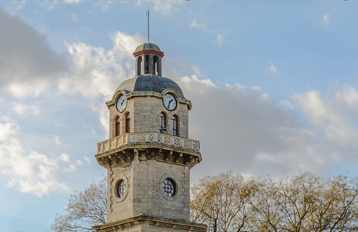 Clock tower in the city of Varna, bulgaria Against blue and cloudy sky.