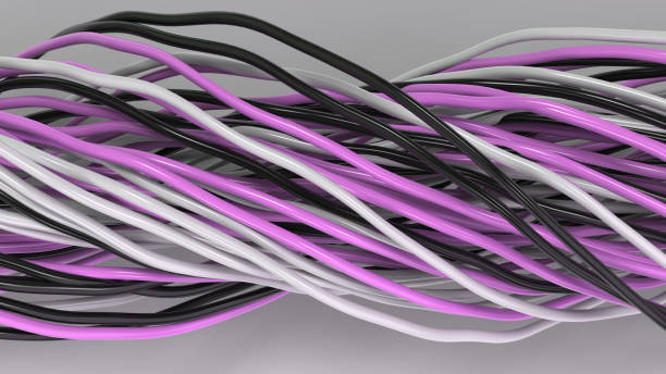 istock Twisted black, white and purple cables and wires on white surface 902867078
