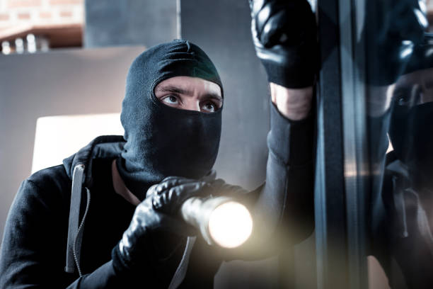 istock Masked burglar holding a torch 902867160