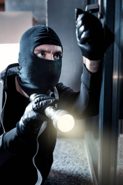 istock Masked thief breaking into the house 902867214
