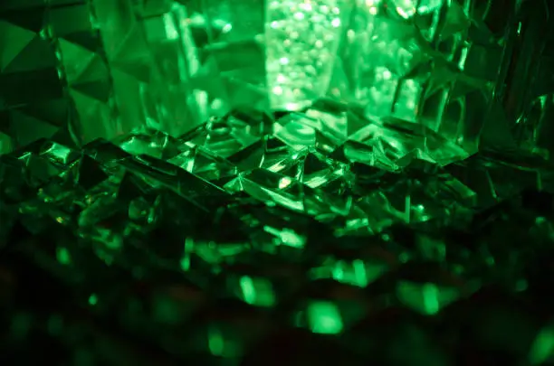 Photo of Close up of cut crystal in mysterious emerald light.Magic shiny background.